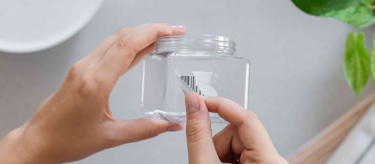 What is the smoothest trick for peeling a stubborn price tag or sticker off a glass jar?